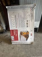 Photo of the original box packaging for the MidWest iCrate 1536 folding dog crate showing product details and a dog image.