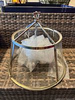 Wide view of pendant light fixture showing glass panels and polished silver metal frame