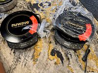 Top angle of both NuWave PIC Gold induction cooktops side by side, showing round black cooking surfaces and wrapped power cords.