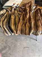 Two vintage women's fur coats in multi-tone brown fur laid flat side by side on a floor.
