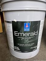 Close-up of a 4.75 gallon Sherwin Williams Emerald paint bucket label showing brand, color, product line, type, finish, and quantity details.