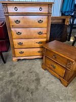 Photo showing the full dresser and nightstand set, highlighting the wood finish and decorative hardware