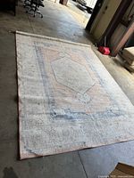 Full view of the large vintage Persian-style area rug laid out flat showing the overall faded blue, peach, and beige pattern and size proportions.