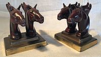 Front angled view of both horsehead bookends showing paint finish and bases