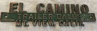 Front view of El Camino Trailer Sales metal badge showing text and mounting holes