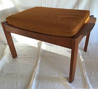Full view of teak ottoman with cushion