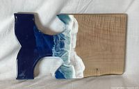 Front view of maple charcuterie board with epoxy whale tail and ocean wave resin edge
