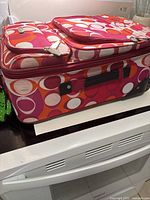 Top and front view of polka dot carry-on with front pockets