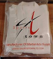 sealed Sports Town bag containing folded white uniform