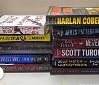 Stacked spines of 11 novels by various thriller authors