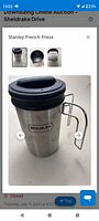 Front view of stainless steel Stanley French press mug showing logo, lid and handle