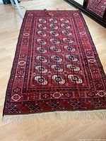 Full view of burgundy Persian-style area rug showing size, pattern, and fringe