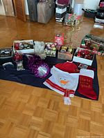 Full lot overview on floor showing ornaments, metal tree, stockings, garlands, party items
