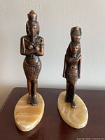 Front view of both Egyptian figurines on stone bases