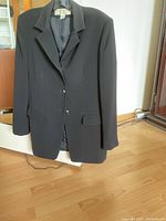 Front view of black blazer showing buttons, lapel and pockets