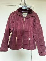 Front view showing color, quilting, gold zipper, zip pockets, collar label