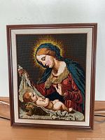 Full view of framed cross-stitch art showing Mary and baby Jesus