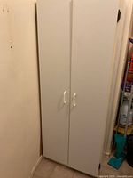 Front view of closed cabinet showing white melamine finish and handles