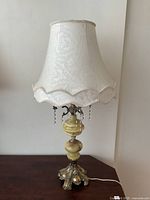 Lamp unplugged showing full view of base, alabaster column, brass fittings, crystal drops, shade