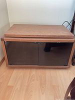 Front view of TV stand with closed smoked glass doors
