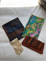 All four items displayed: scarf, pillow sham, gloves, purse