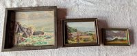 Front view of three framed paintings side by side