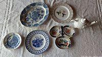 Group shot showing all nine china items: Ridgeway platter, four Wedgwood plates, Adderley plate, Losol Ware tray, Avon elephant teapot