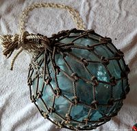 Close view of glass float in jute netting showing color, texture, and net detail