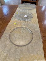 Photo showing all three clear glass serving platters on a table, highlighting varied shapes and textures.