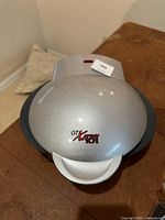 Closed view of GT Xpress 101 countertop cooker showing silver metallic finish and red indicator light with model logo on top.