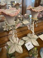 Full view of the two Lenox porcelain floral pieces showing trumpet flowers, butterfly details, leafy base, and hanging crystal drops.