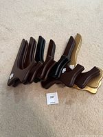 Seven folding display easels in a row showing colors including dark brown, black, and gold.