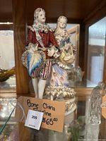 Front-facing photo of the regal colonial couple bone china figurine showing detailed painting and attire
