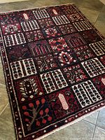 Full view of rectangular Bakhtiari Persian rug showing the entire brick style pattern of colored squares and motifs on tiled floor.