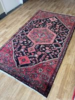 Full view of rug laid flat on floor, shows overall pattern and colors