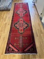 Full length view of red Zanjan runner rug laid on floor showing overall pattern and condition