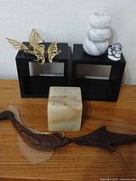 Group shot showing alabaster tic-tac-toe block, teak wall plaques, brass butterflies, marble candle holders, figurine, black display cubes