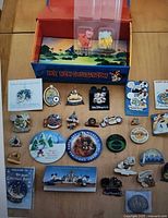 Overview of Disney pins, box, and part of Hard Rock pins