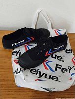 Pair of Feiyue sneakers on branded bag