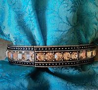 Front view of Heidi Daus bangle showing round and square champagne crystals on bronze-tone frame