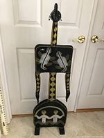 Full view of tall carved figurine showing bead designs of turtles and people