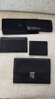 Four black leather wallets laid flat on couch
