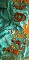 Group view of all jewelry pieces on turquoise fabric background
