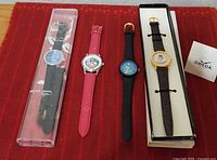 Group shot of four Disney character watches on red surface