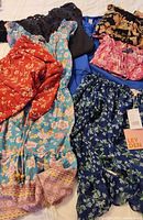 Overview of nine garments laid out on bed