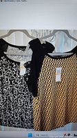 Both tops hanging: black/white print and yellow/black polka dot