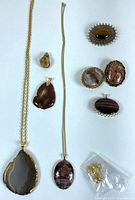 Group view of two necklaces, two loose pendants, four brooches/pendants and findings