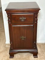 Front view showing drawer, cupboard door, hardware, feet