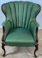 Front view showing channel back, upholstery, wood legs and arms