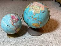 Both globes side by side showing comparative sizes and stands